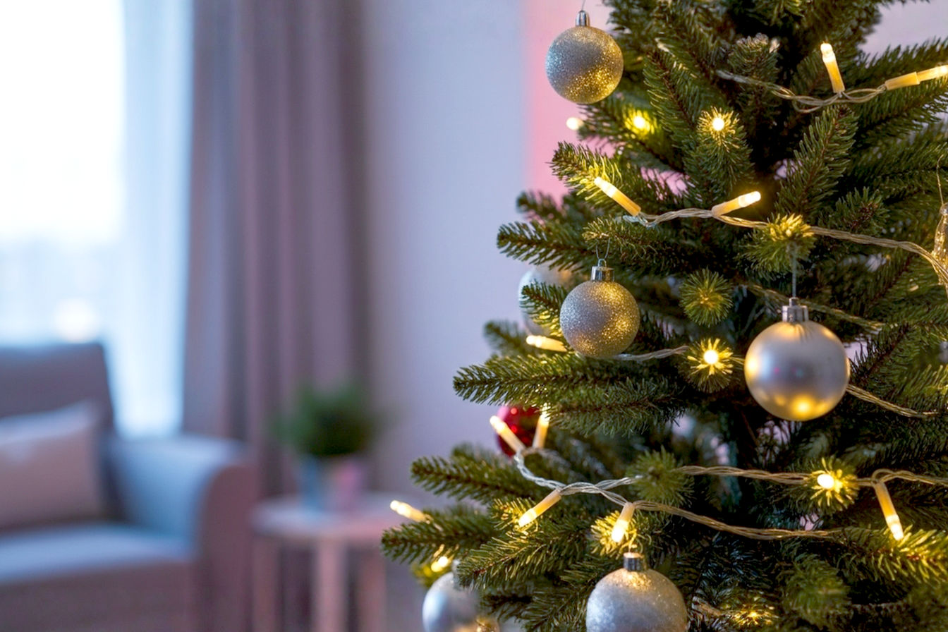 A professional, lifelike photograph of a beautifully decorated Christmas tree, illuminated with warm white battery-operated LED lights. The scene should be cozy and inviting, with a soft, bokeh background of a living room at dusk. Focus on the seamless glow of the lights, emphasizing the absence of visible cords or plugs. The composition should highlight the magical ambiance created by the lights. Use a shallow depth of field to make the tree and its lights pop. The lighting should be soft and warm, emanating from the tree, with subtle reflections on nearby ornaments. The overall mood is festive, peaceful, and elegant.