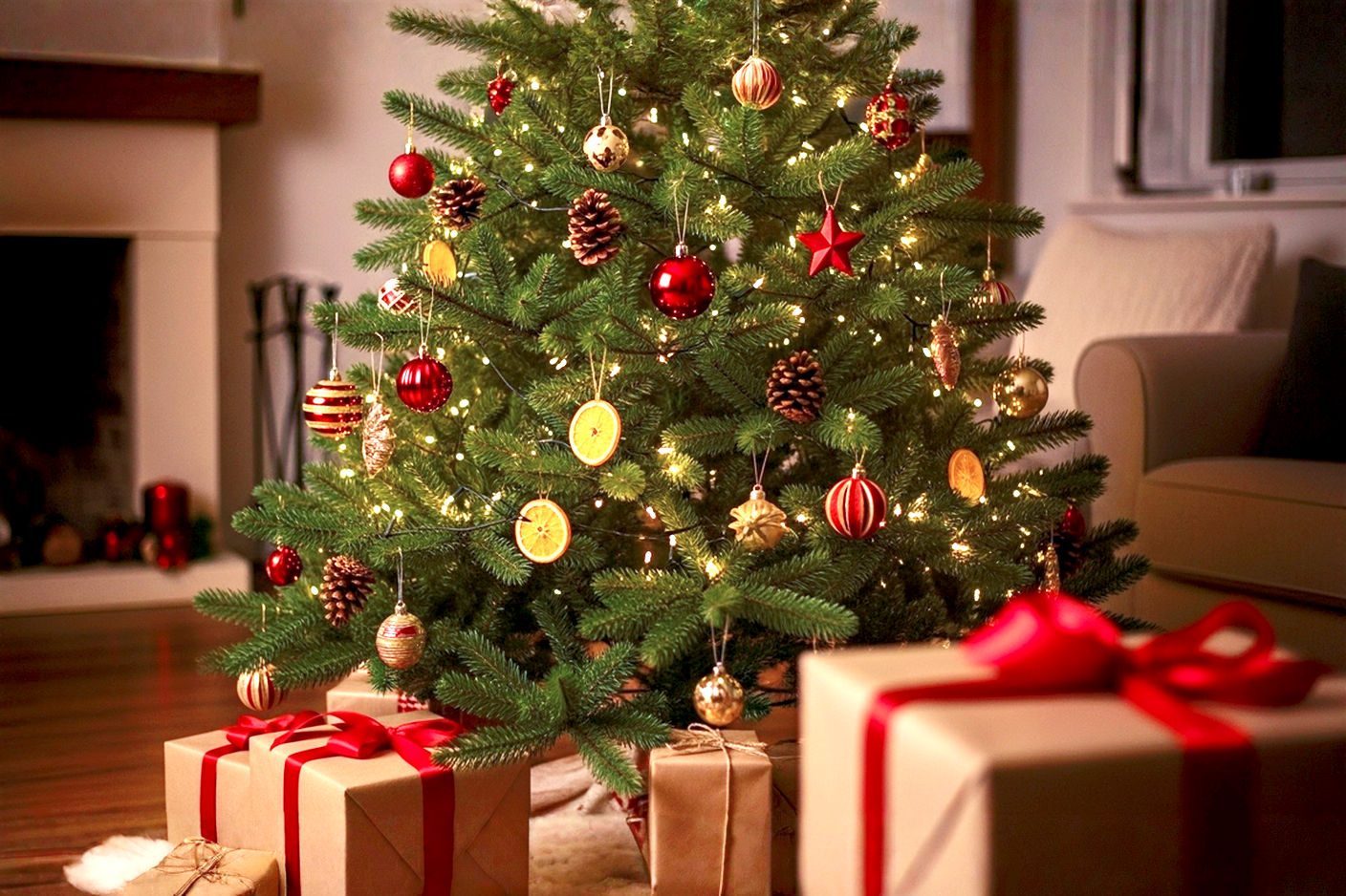 Professional, lifelike photograph of a beautifully decorated natural Christmas tree standing prominently in a cozy, warmly lit living room. The tree is a vibrant green Fraser Fir, adorned with a mix of traditional and natural ornaments: classic red and gold baubles, dried orange slices, real pinecones, and warm white LED lights that cast a soft glow.