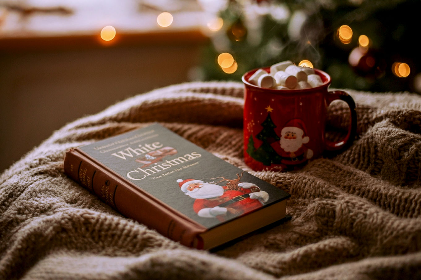 A warm, inviting, lifelike professional photograph of a classic, well-worn hardback book titled "White Christmas" resting on a cozy, textured wool blanket next to a steaming mug of hot cocoa. In the soft-focus background, a subtly decorated Christmas tree with twinkling warm lights is visible through a window, hinting at a snowy landscape outside. The lighting should be soft, diffused, and warm, creating a nostalgic and comforting mood. The composition should be a close-up, slightly elevated shot, emphasizing the book as the central subject, with a shallow depth of field. Colors should be rich and warm, dominated by creams, browns, and festive reds/greens from the background.