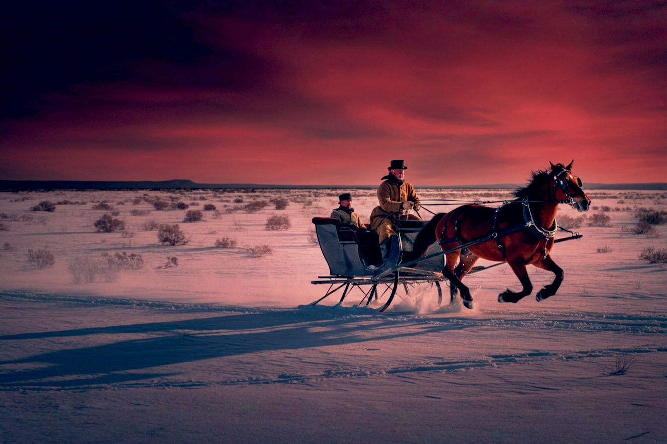A highly detailed, professional photograph capturing a historical winter scene from the 1850s. In the foreground, a one-horse open sleigh driven by a man in period attire races across a snow-covered field under a crisp, blue sky. The horse, a bay with a bobbed tail adorned with sleigh bells, is in mid-trot, kicking up powdery snow. The scene evokes a sense of speed, cold air, and exhilarating 19th-century fun, subtly hinting at the song's origins in sleigh racing. Use realistic lighting, rich textures on the wooden sleigh and woolen clothes, and a dynamic composition that feels authentic and historically accurate. The mood is energetic and nostalgic, not overtly festive or Christmas-themed.