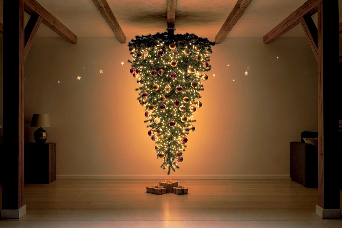A professional, lifelike photograph of an elegantly decorated Christmas tree hanging upside down from a rustic, exposed wooden beam ceiling in a cozy, softly lit living room. The tree's branches cascade downwards, adorned with classic, warm-toned ornaments and subtle, glowing fairy lights. Below the tree, the floor space is noticeably clear, perhaps with a few neatly wrapped gifts, emphasizing the space-saving aspect. The composition should highlight both the traditional charm of the decorations and the striking, unusual orientation of the tree. The lighting is warm and inviting, creating a festive yet sophisticated mood. Focus on sharp detail and a shallow depth of field to make the tree stand out.